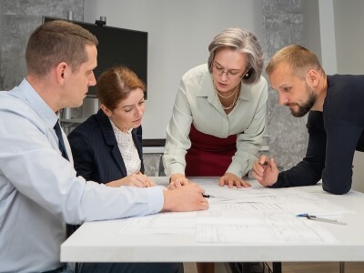 Four colleagues review plans in a meeting