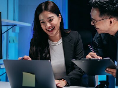 Business professionals collaborating on market analysis and AI driven data insights during focused late night office work.
