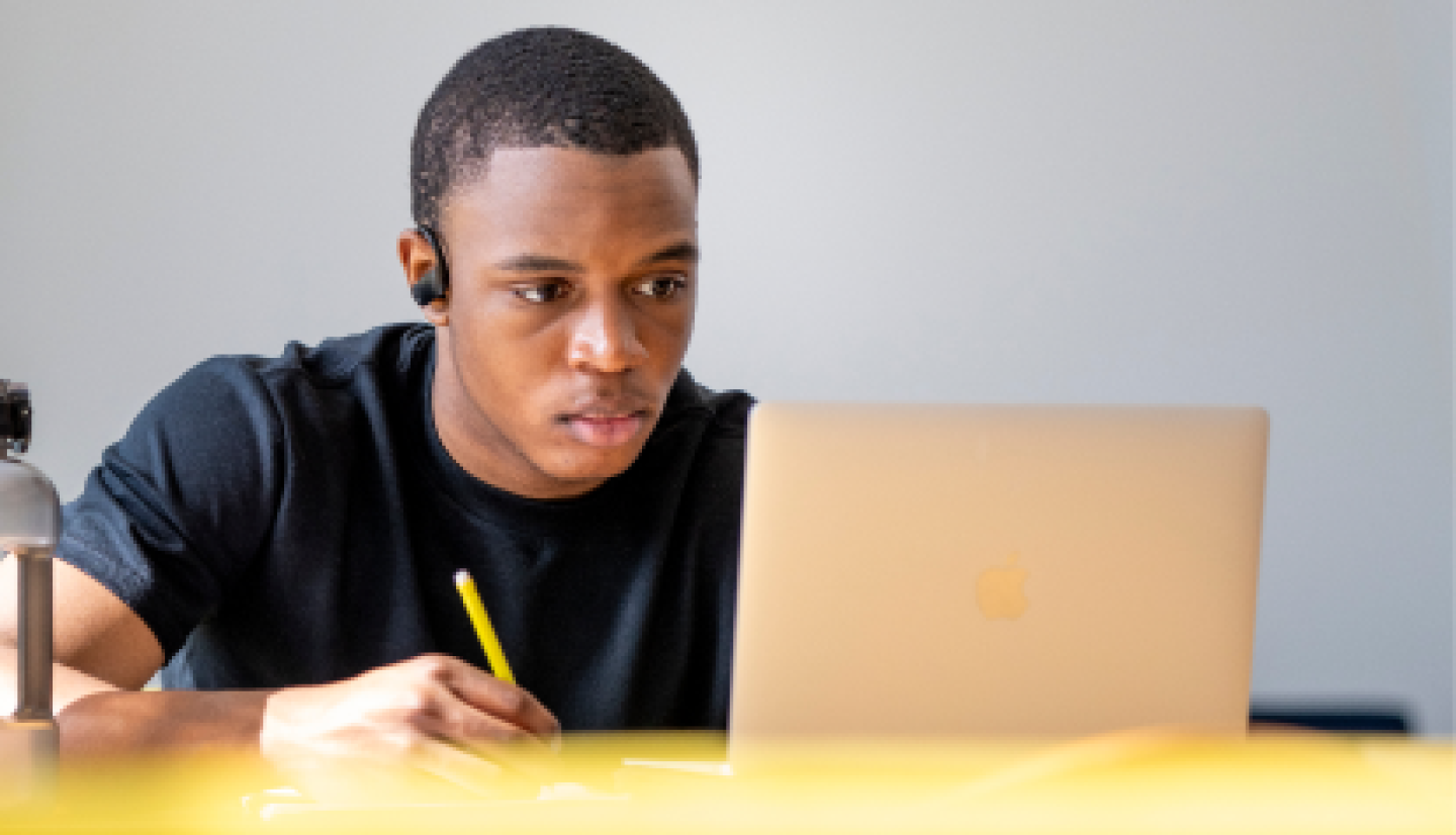 Close-up of a male CWRU student reviewing lessons on a laptop.