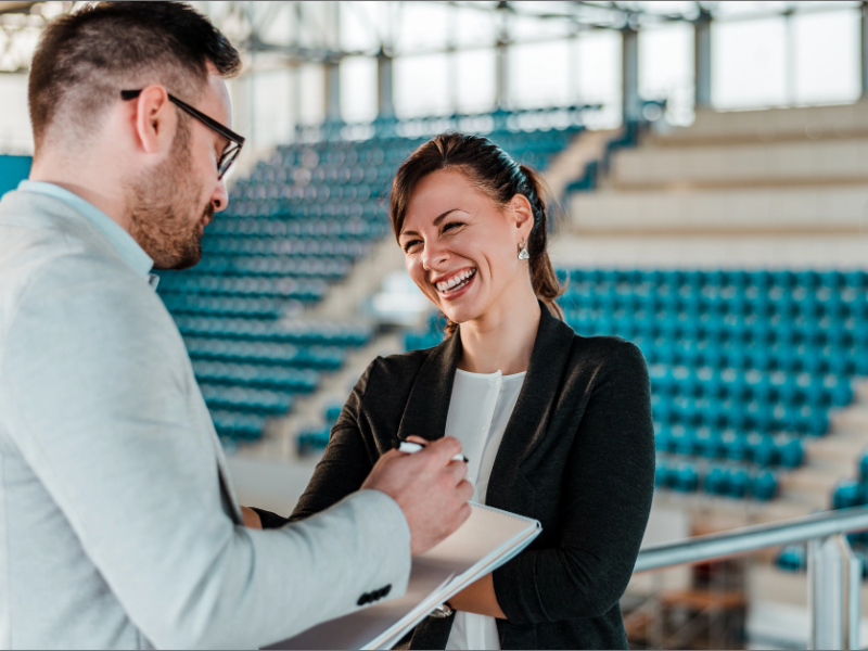 Athletic Director meeting with an associate in a sport arena