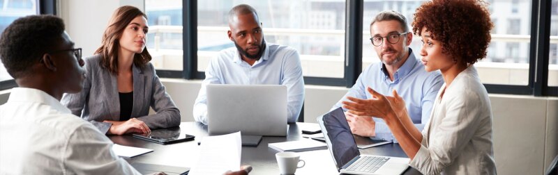 Millennial black businesswoman addressing colleagues at a corporate business meeting, close up.