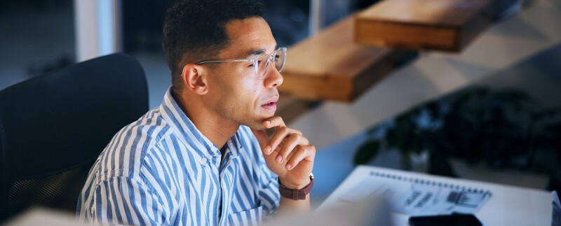 Professional is focused and thinking while working at his computer