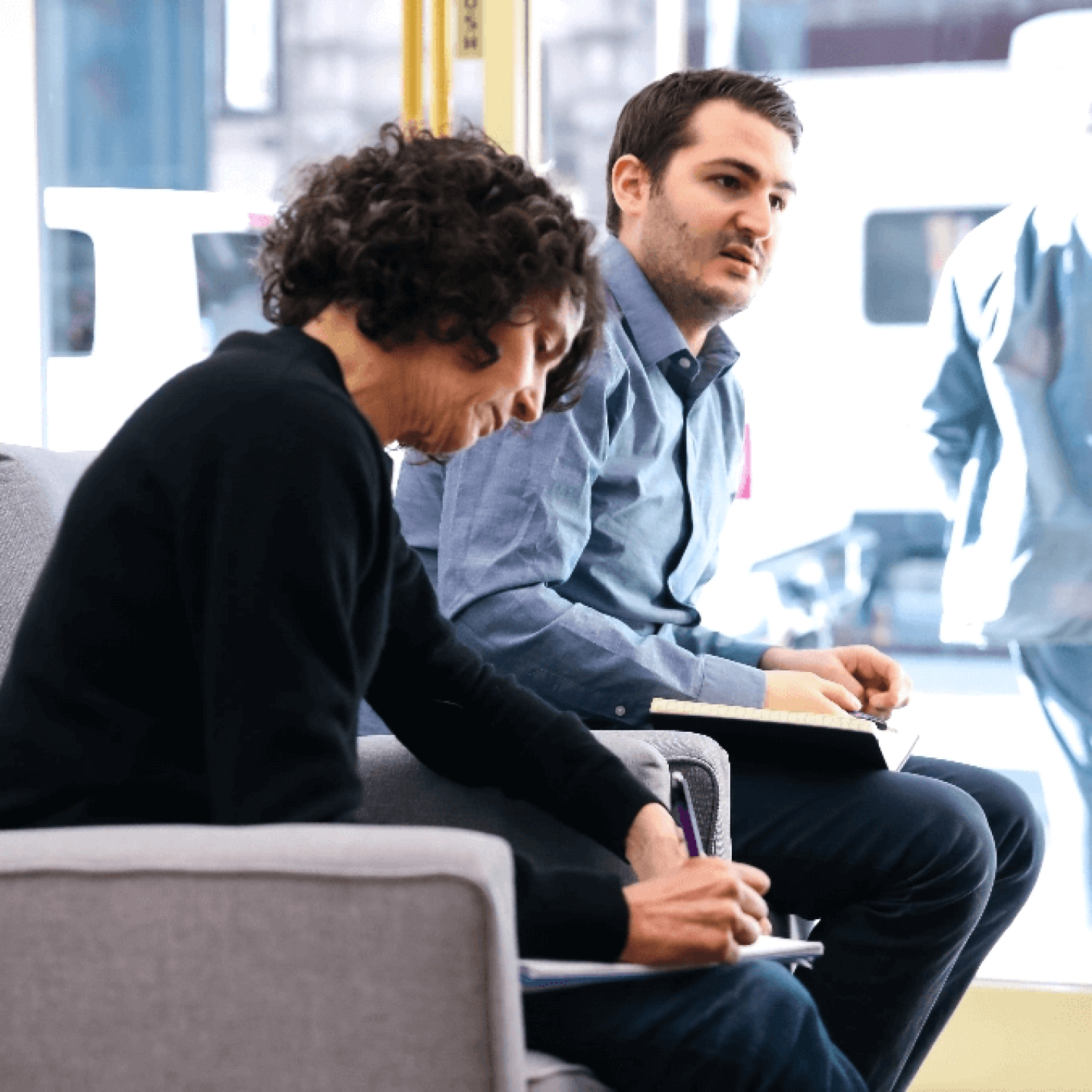 Man and woman talking and taking notes