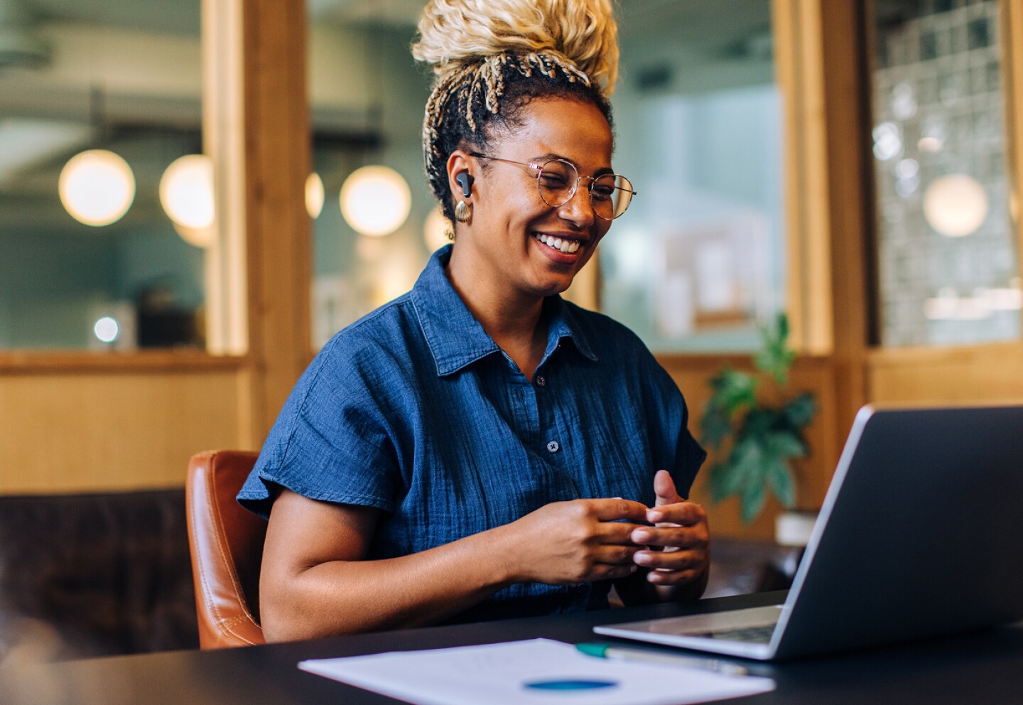 Smiling female student in a virtual meeting on her laptop