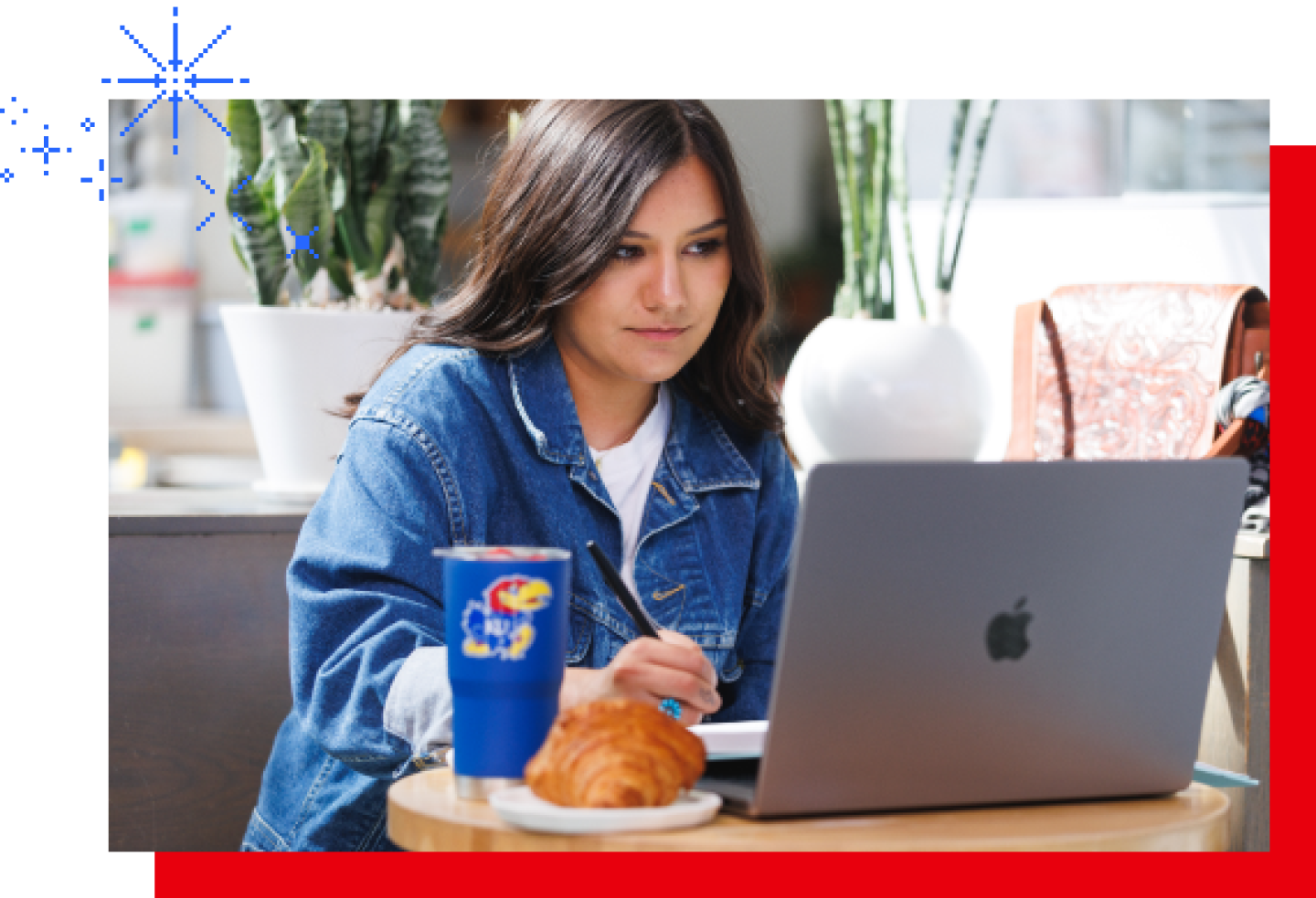 A female KU student is working on a laptop.