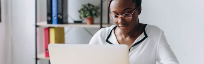 focused woman sitting at desk using laptop