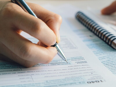 Close-up shot of someone filling out a 1040 form.