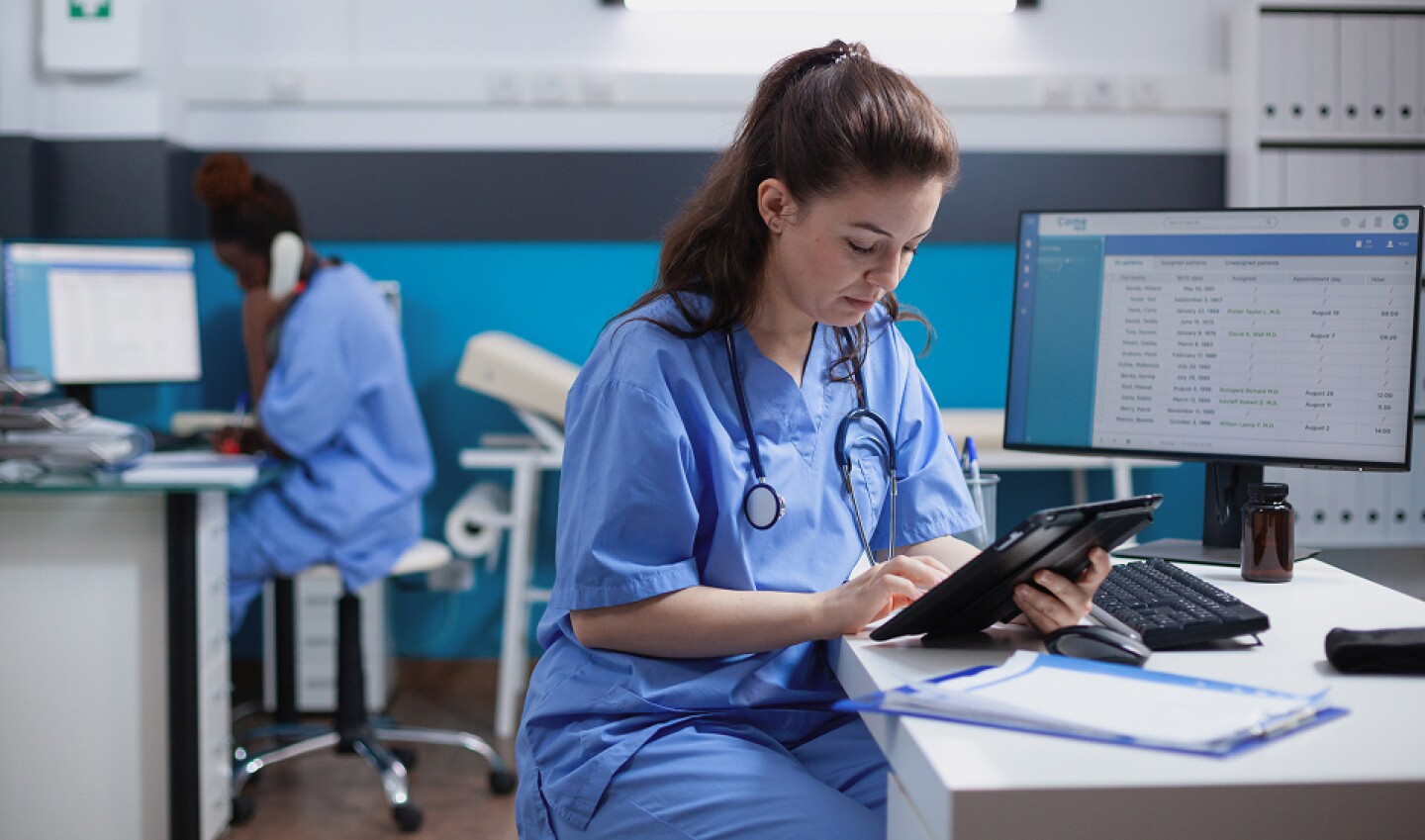 Nurse focused on a tablet at her station