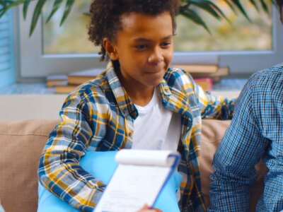 Social worker consulting smiling young single father with kids at home.