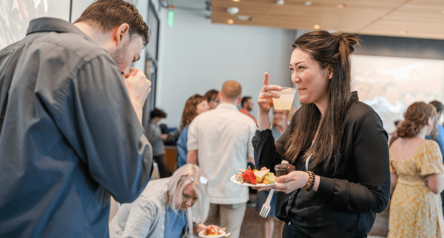 Man and woman eating and laughing at networking event