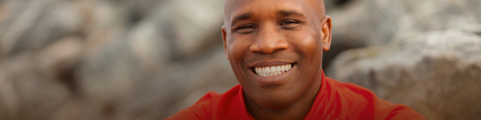 Man smiling in red shirt