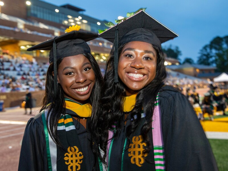 Two women smiling at their graduation ceremony