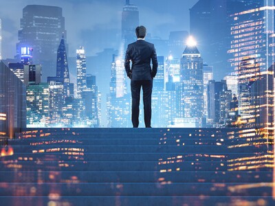 Executive at top of stairs overlooking cityscape