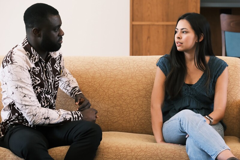 Two William and Mary student talking on a couch