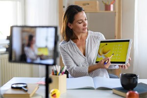 Female teacher providing an online lesson to her students, using advancements in online learning technologies.