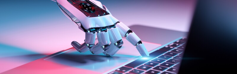 Robotic hand pressing a keyboard on a laptop