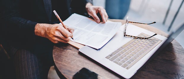 Man at a cafe reads about the Dean of YU Sy Syms, Dr. Noam Wasserman.