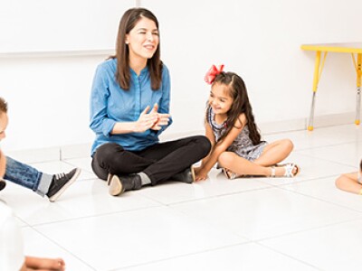 teacher and students sitting on floor in circle