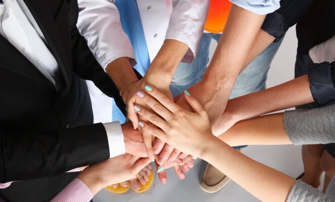 Group of hands in the middle of a circle of people