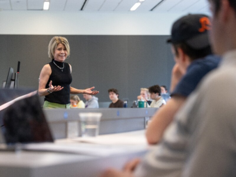 A female KU professor stands in front of the classroom.