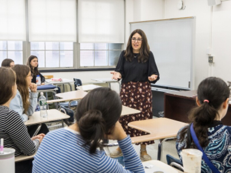 A female MSW professor is engaging in discussion with her class.