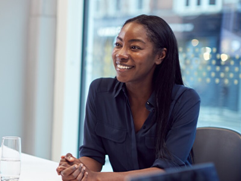 woman with hands folded in conversation with someone