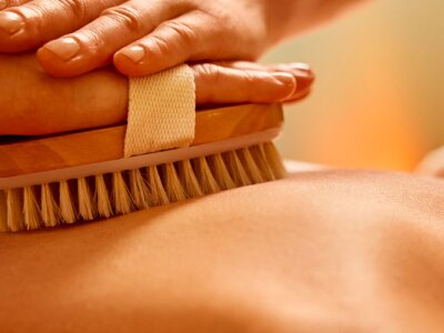 Close-up of woman having dry brush massage at spa.