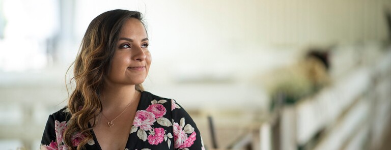 Young female Chico State student wearing floral print dress and smiling