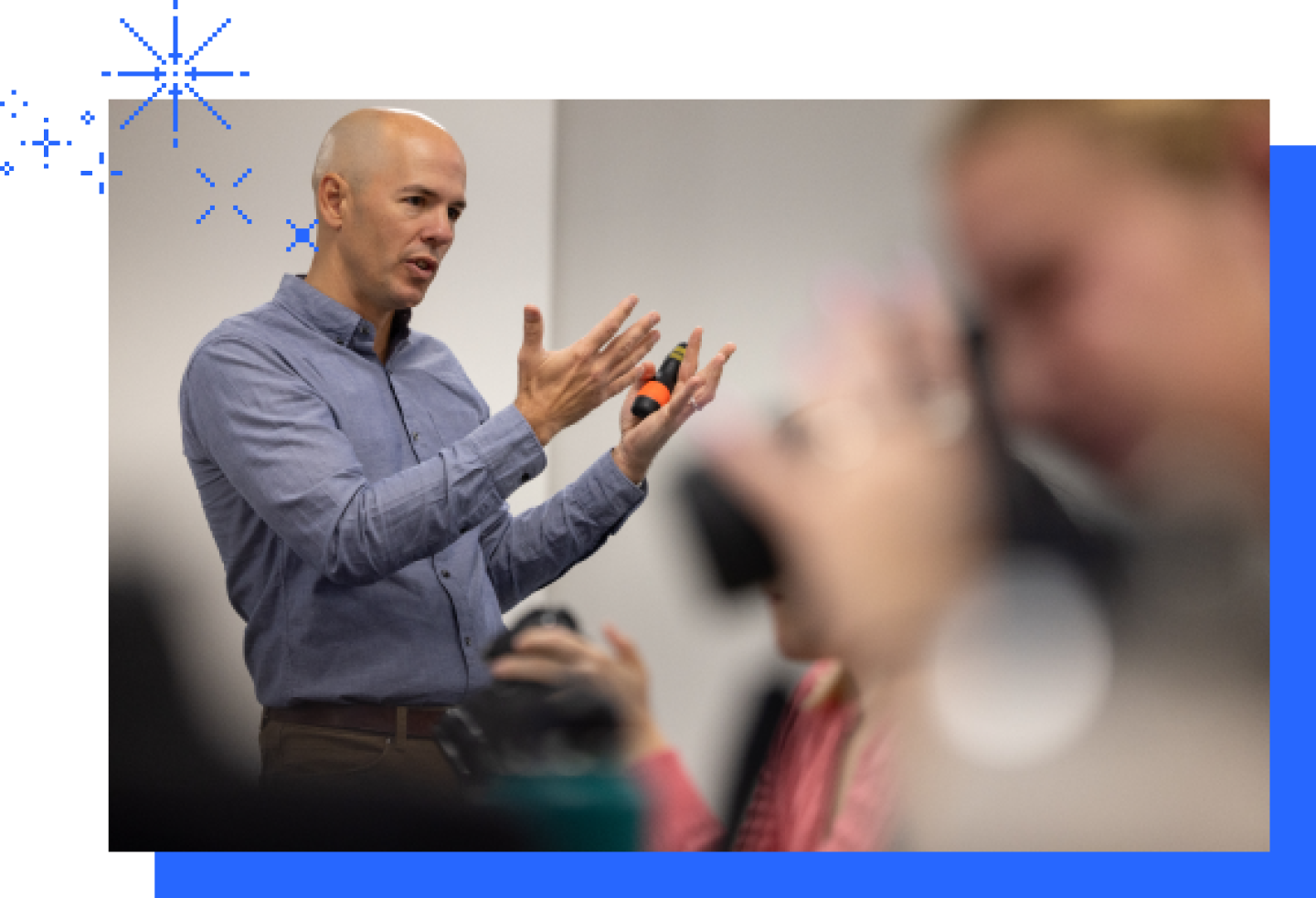 A male KU professor demonstrates a lesson with his hands in the classroom.