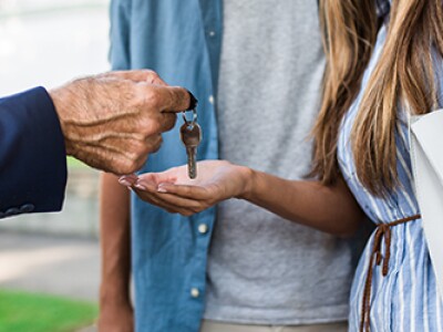 Man hands a pair of keys over to a couple