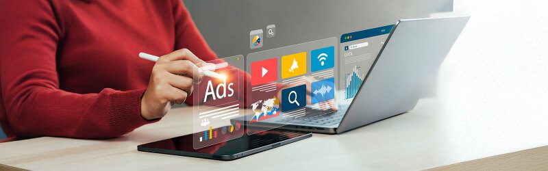 A person working on a marketing ad on a laptop.