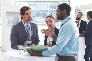 Business people discussing over documents at table during a seminar