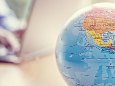 Globe-Of-The-World-With-Man-Working-On-Laptop