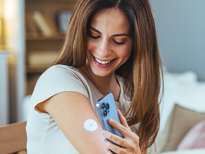 Woman monitoring glucose levels with smartphone at home.
