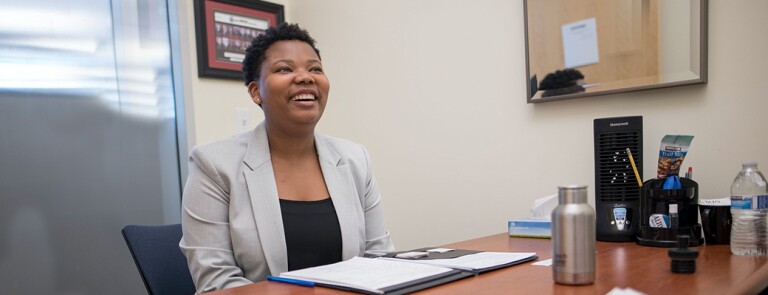 Professional Chico State student wearing a blazer and smiling in her office