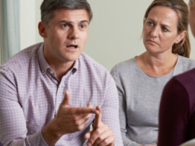 Members Of Support Group Sitting In Chairs Having Meeting