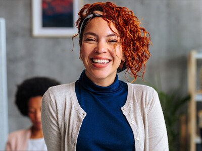 Woman smiling in office among colleagues