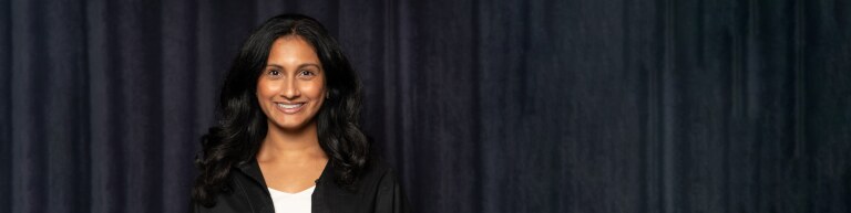 Northwestern IMC student smiling in front of a black curtain