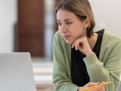 Student older than 30 works on a laptop in a library