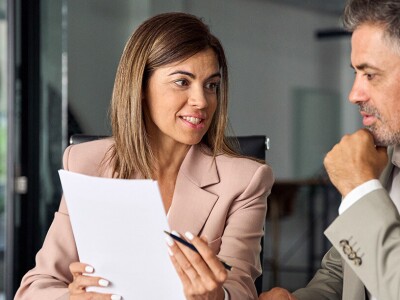 Man and women in business dress looking at documents together.