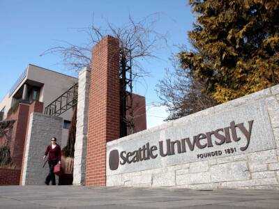 Student walking through entrance to Seattle University's campus