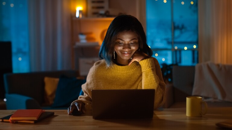 Portrait of Beautiful Black Girl Uses Computer while Sitting at