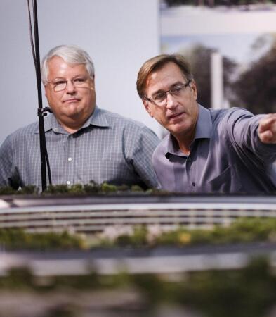 Two men surveying scale model of building Silicon Valley