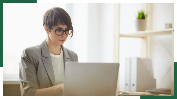 Woman with glasses working on laptop
