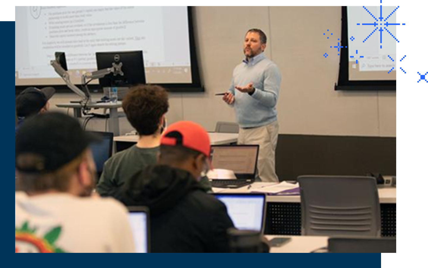 Male professor standing in front of class instructing students.