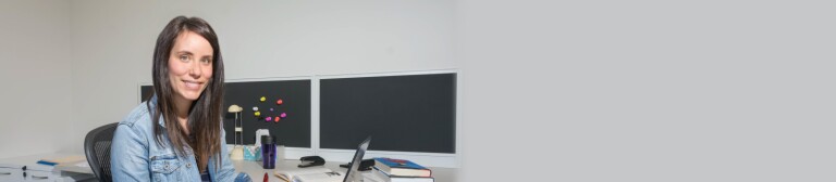 IMC Part Time student sits at desk while working on a laptop