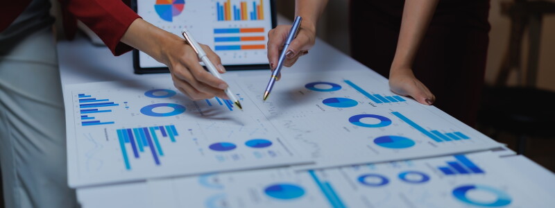Two business analytics colleagues collaborate on data visualization graphs
