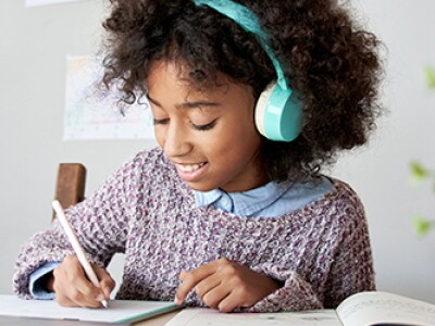 girl-wearing-headphones-writing-on-a-piece-of-paper