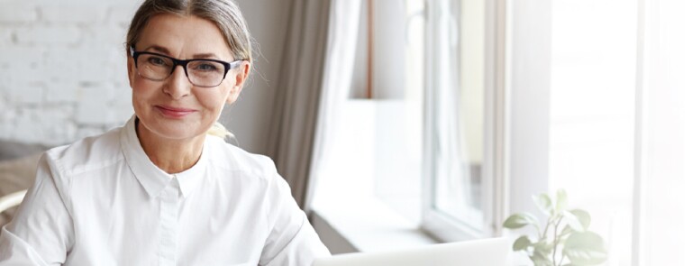 smiling woman wearing a white dress and glasses