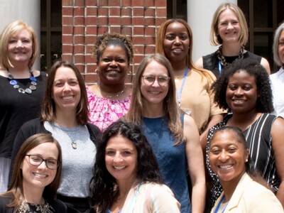 Students attending Tulane Law's Immersion Weekend events pause for a group photo in front the a building.